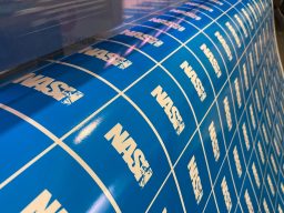 Blue vinyl stickers with repeated white NASH logos arranged in a grid pattern.