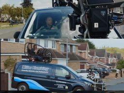 A film crew captures a scene with a camera mounted on a van and a person inside. Signography made the print for this vehicle prop.